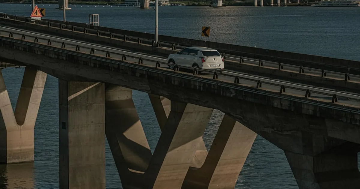 a car driving on a bridge over a body of water