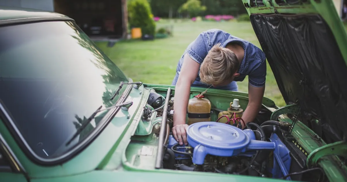 man checking vehicle engine