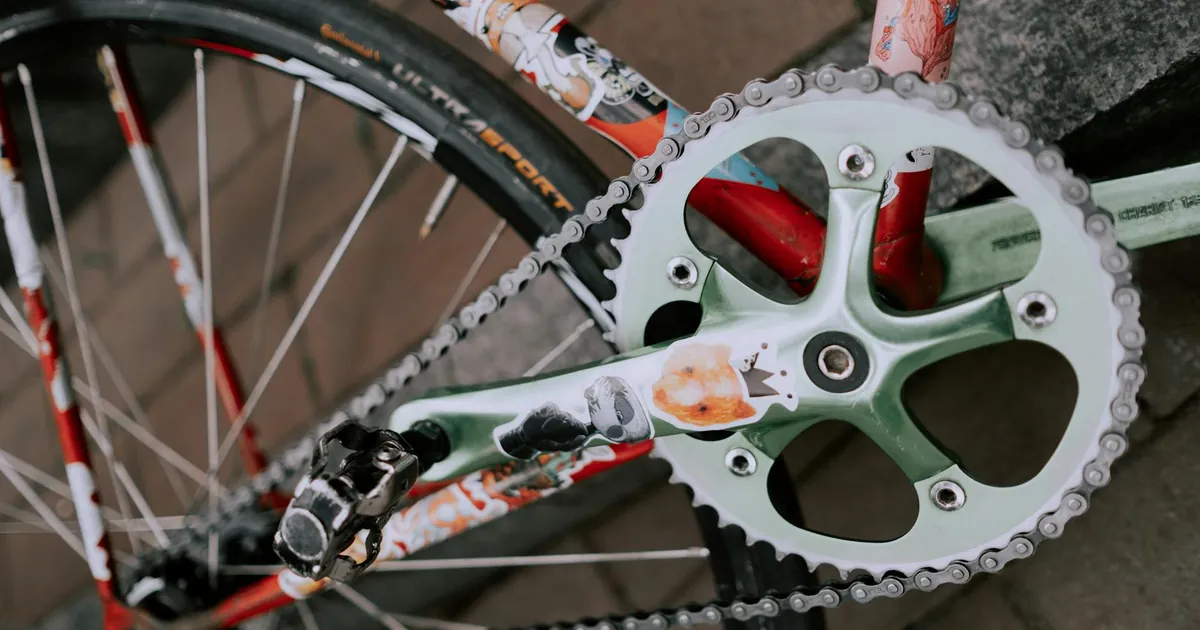 Artistic close-up of a bicycle crankset showcasing vibrant graphics, focusing on the unique design.