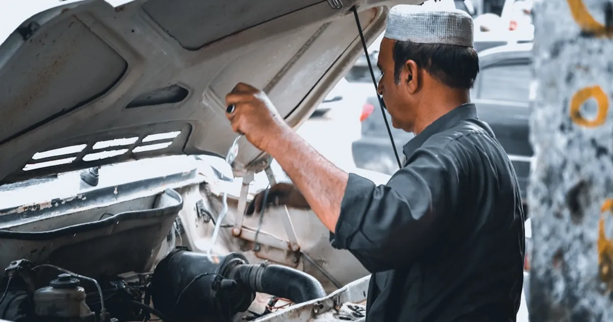 man repairing white vehicle